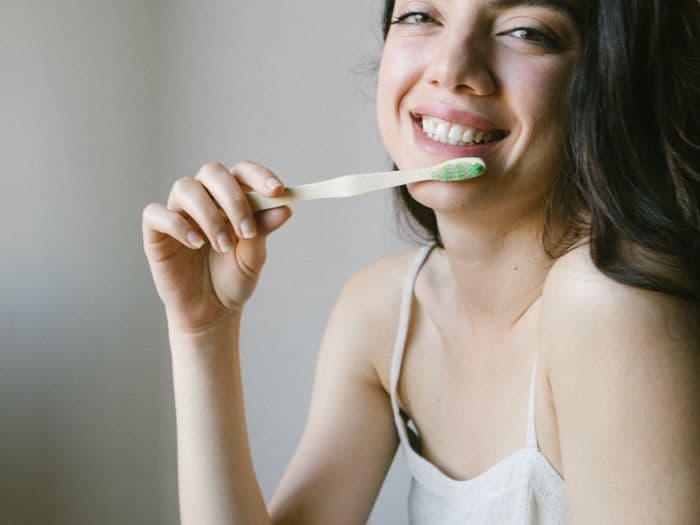 Woman smiling naturally while caring for her bright teeth